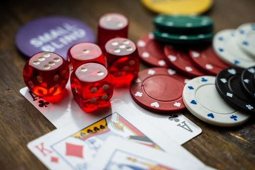 Five red dice, a small blind chip, ace of clubs, king of diamonds, and poker chips all feature in free casino games.